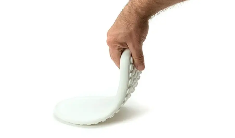 Favism3D: Impresión 3D con TPU para prototipos, juntas y piezas flexibles de alta durabilidad. Mano doblando una pieza impresa en 3D con filamento TPU flexible, demostrando su elasticidad y resistencia.