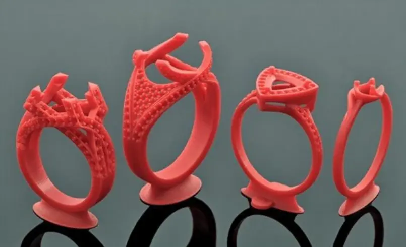 Favism3D: Impresión 3D con resina calcinable para modelos de joyería, fundición a la cera perdida y prototipos de precisión. Cuatro anillos detallados impresos en 3D con resina calcinable roja, listos para el proceso de fundición de joyas.