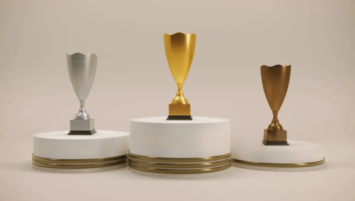 Trofeos personalizados impresión 3D, premios deportivos, reconocimientos empresariales, galardones a medida, trofeo oro plata bronce, fabricación aditiva, Málaga. Conjunto de tres trofeos personalizados impresos en 3D, en acabados plata, oro y bronce, exhibidos sobre pedestales para premios y reconocimientos.